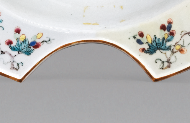 圖為清中期粉彩花卉紋剃須盤(pán)細(xì)節(jié)圖，該盤(pán)是男士剃胡須時(shí)使用的，弧形缺口能夠卡住下巴，刮起胡須來(lái)更方便。（來(lái)源：廣州十三行博物館）